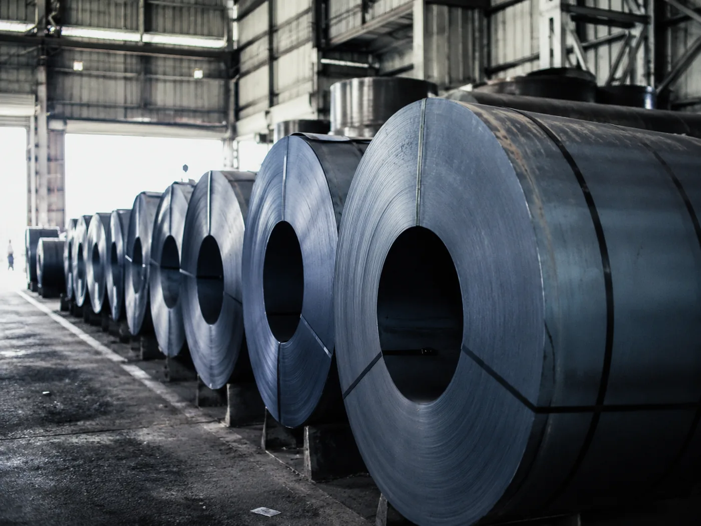 Rolled steel coils stored in a factory warehouse