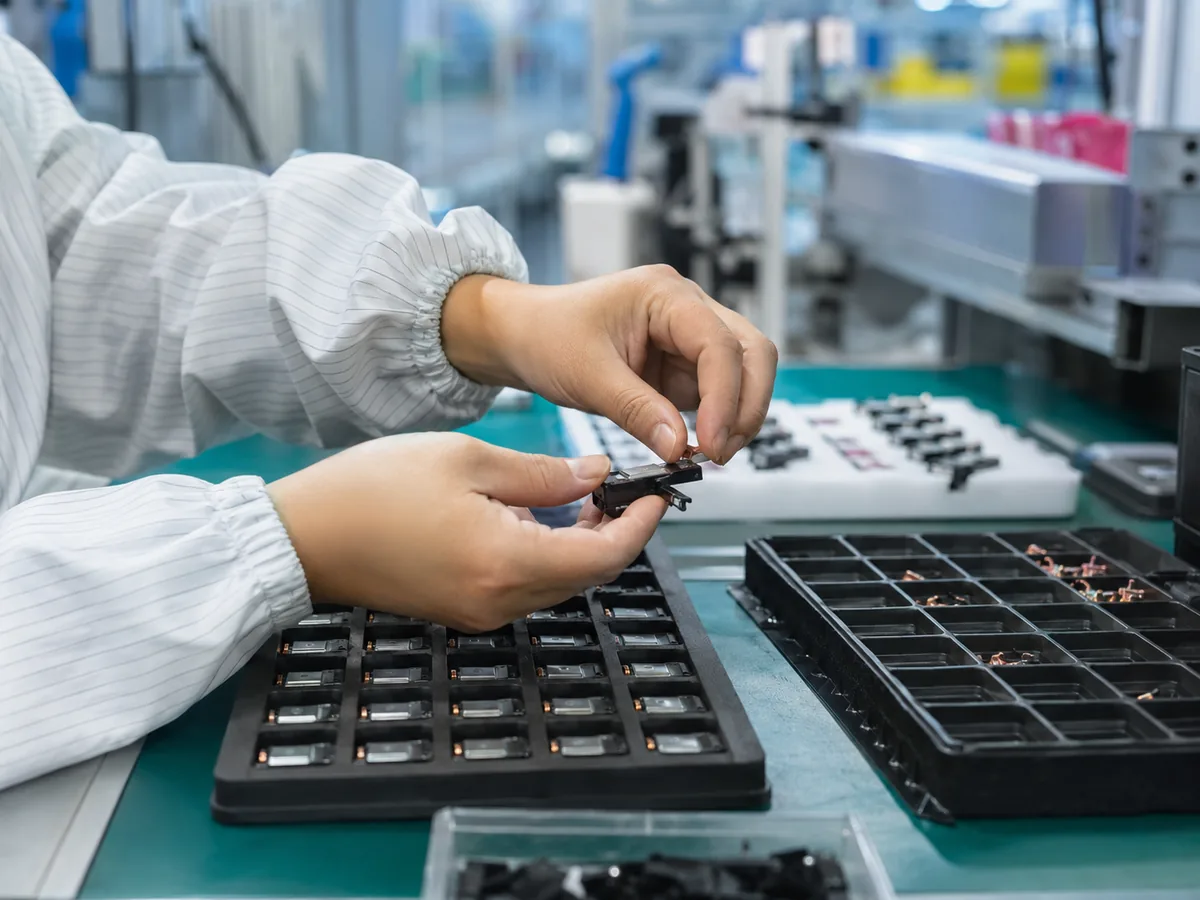 Technician assembling components on an OEM production line